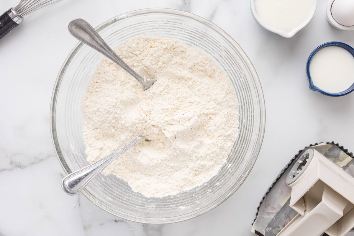 Frozen butter mixed into the flour mixture in a bowl.