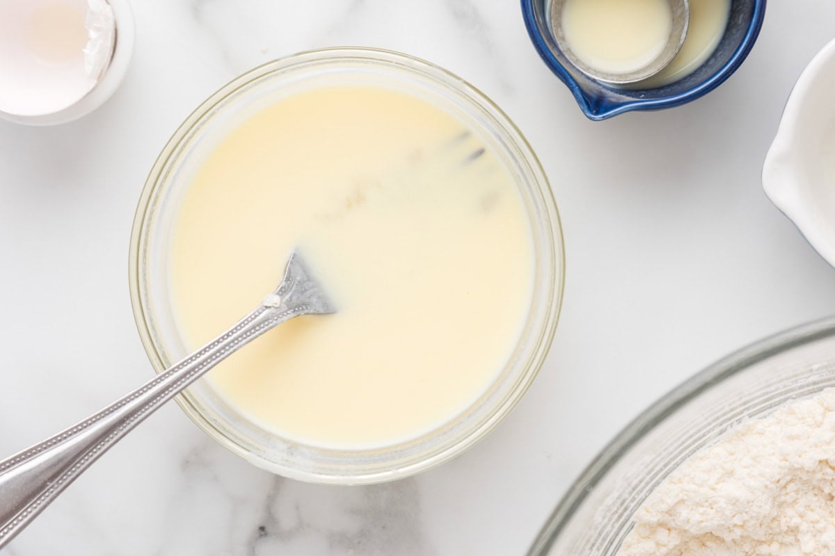Buttermilk, egg and milk in a bowl mixed together.