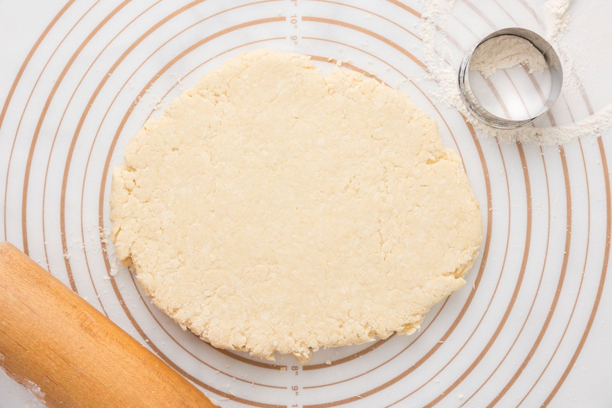 Disc of English scone dough rolled out slightly to a thinner width.
