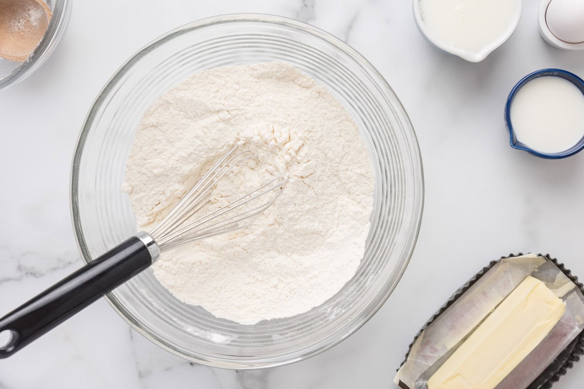 Flour, baking powder, baking soda, sugar, and salt whisked together in a bowl.