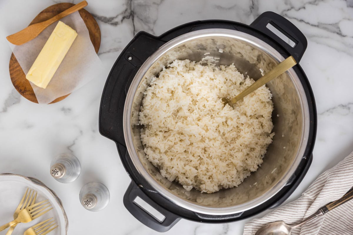 Rice in the instant pot being fluffed with a fork.
