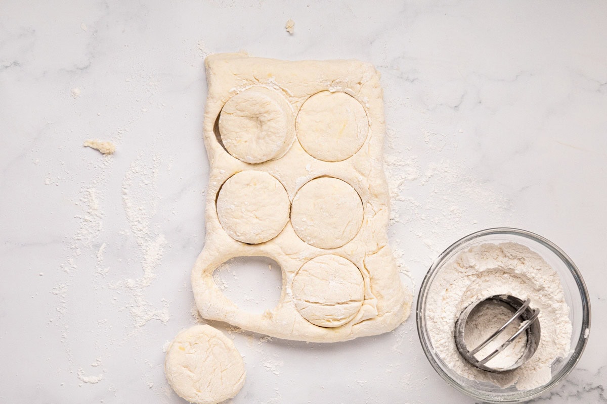 A rectangle shaped biscuit dough with the biscuits circles cut out.
