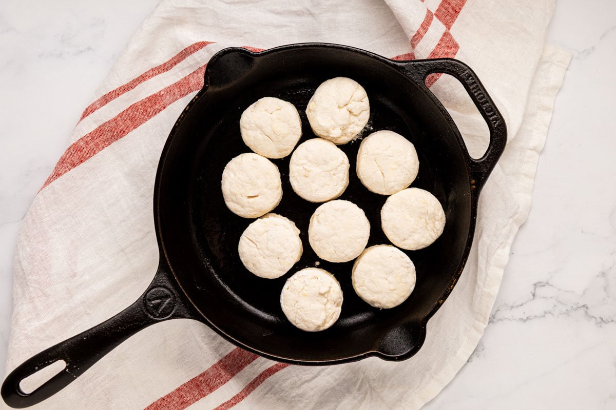 Round raw biscuit dough in a cast iron skillet.