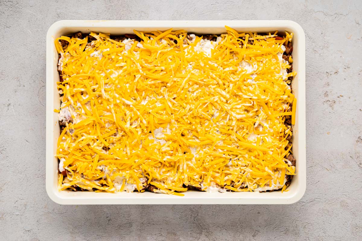 Shredded cheddar cheese placed on top of the casserole before baking.
