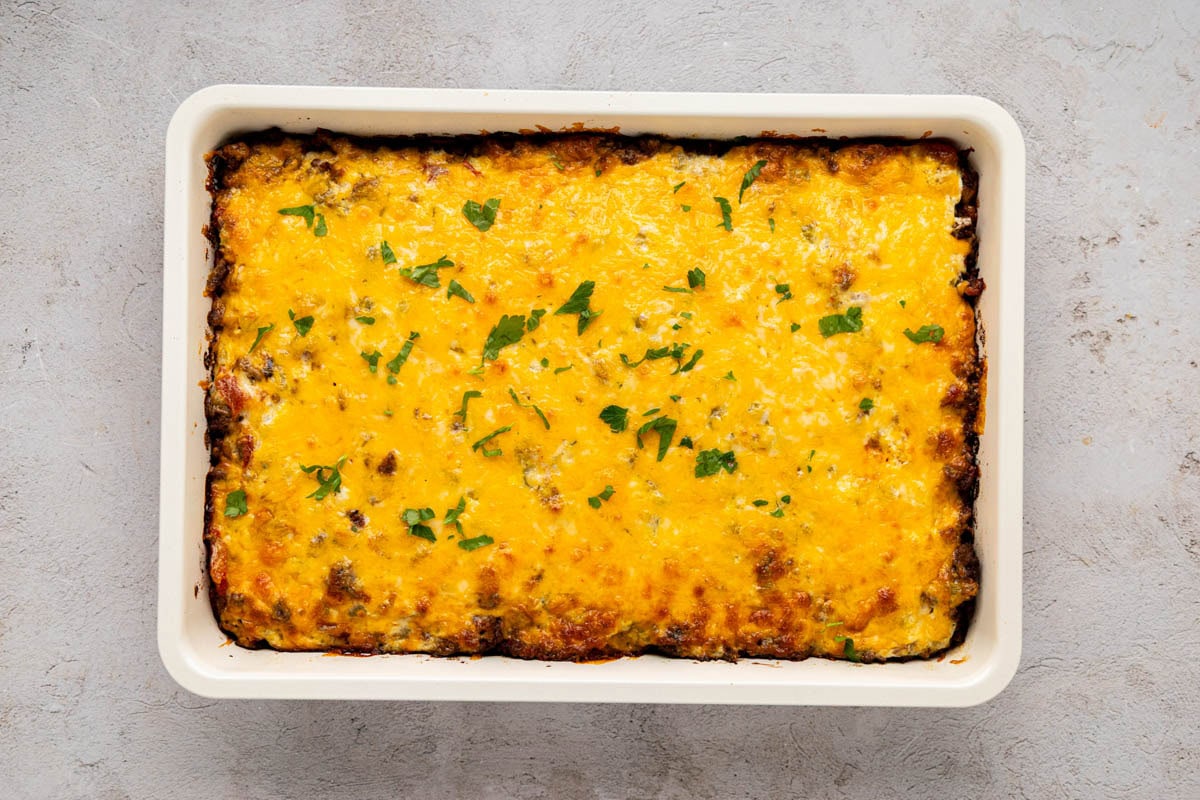 Baked cattle drive casserole in a baking dish garnished with parsley.