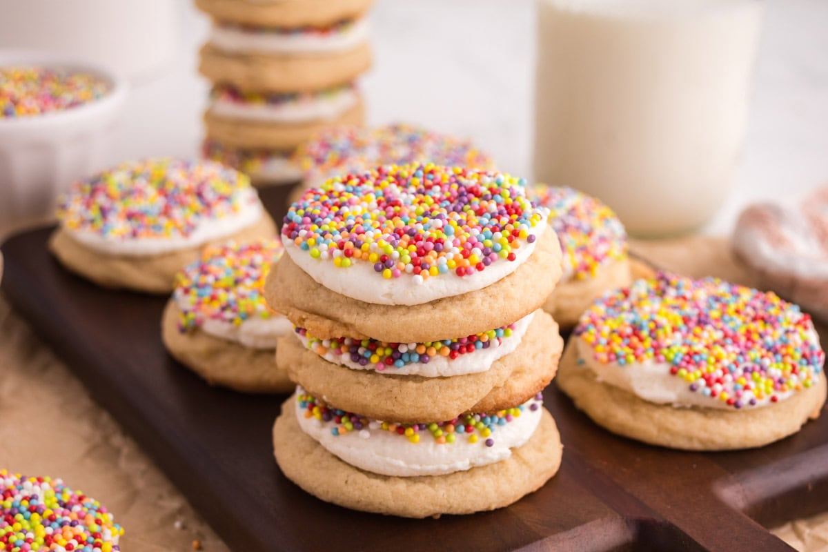 Side view of dot cake cookies stacked on top of each other on a wooden board.