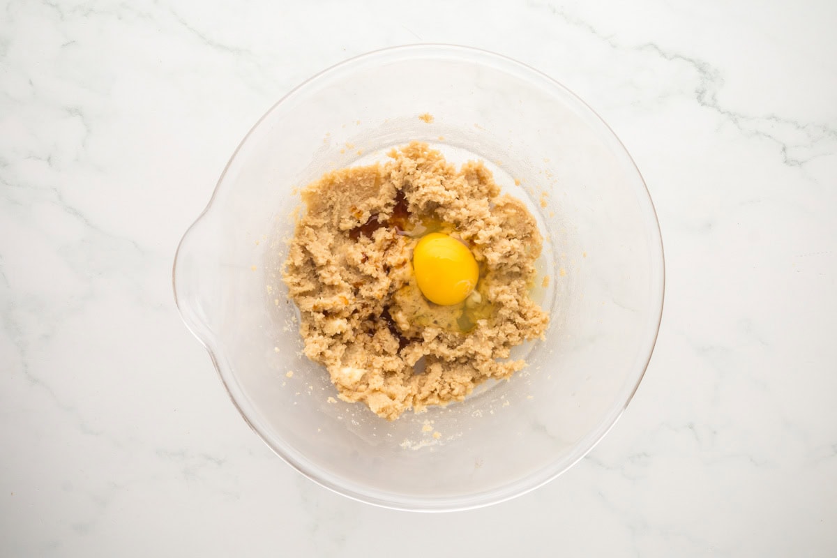 Egg added to the creamed butter and sugar in a bowl.