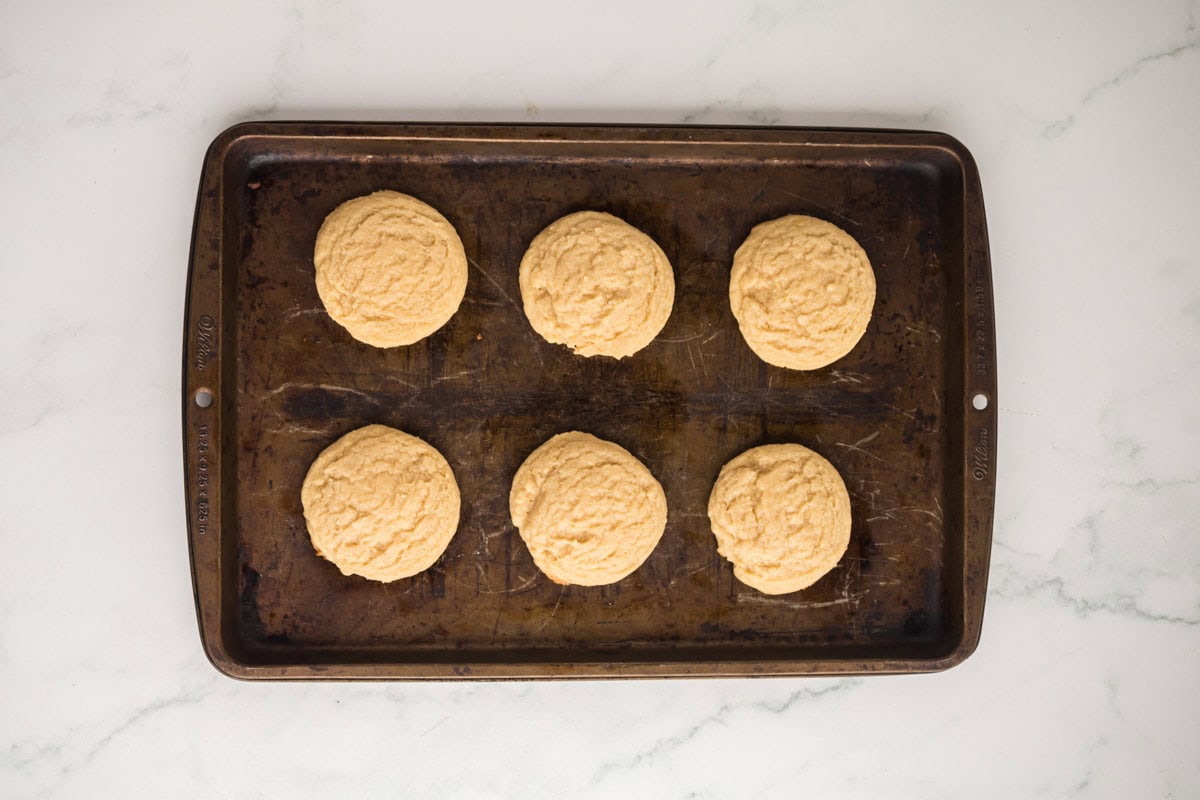 Baked sugar cookies on a sheet pan.