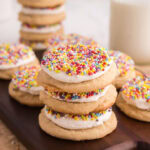 Dot cake cookies stacked on top of each other on a wooden board.