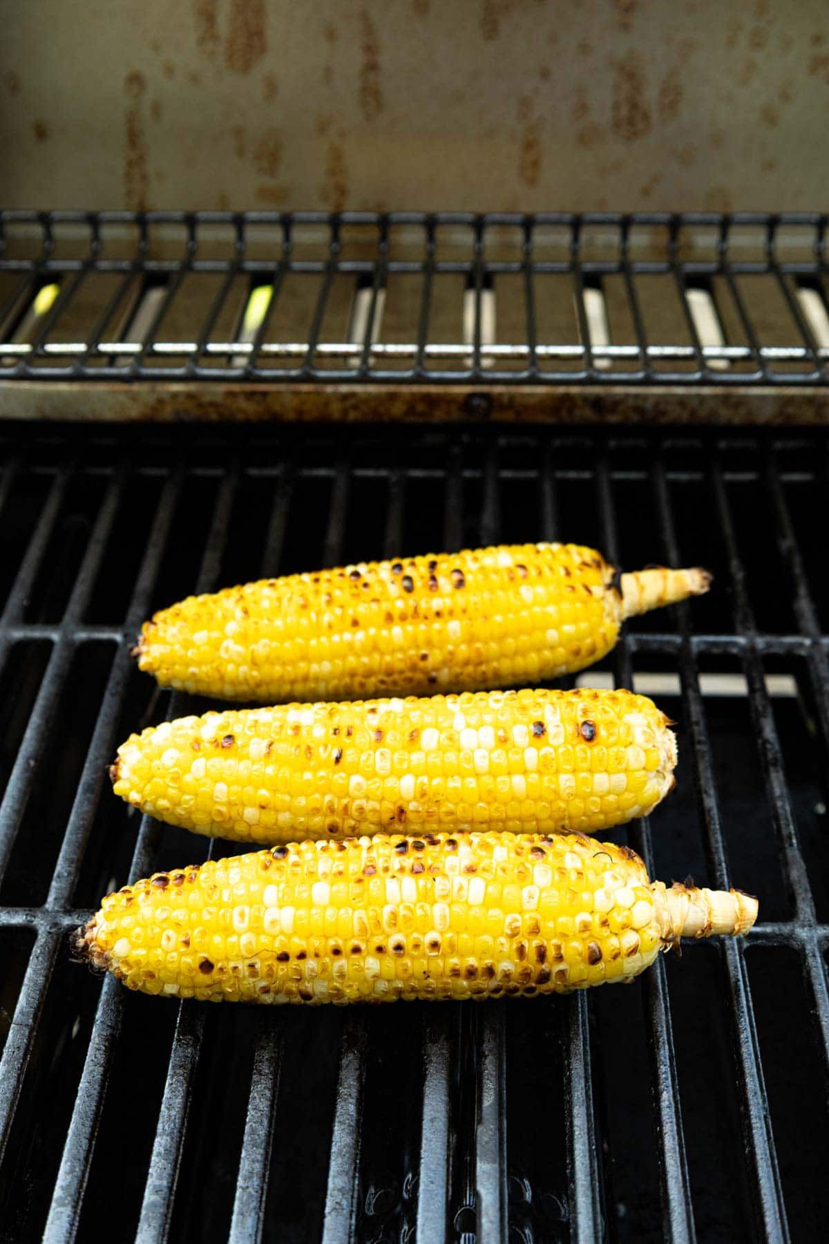 Corn without husk on directly on the grill with a nice char.