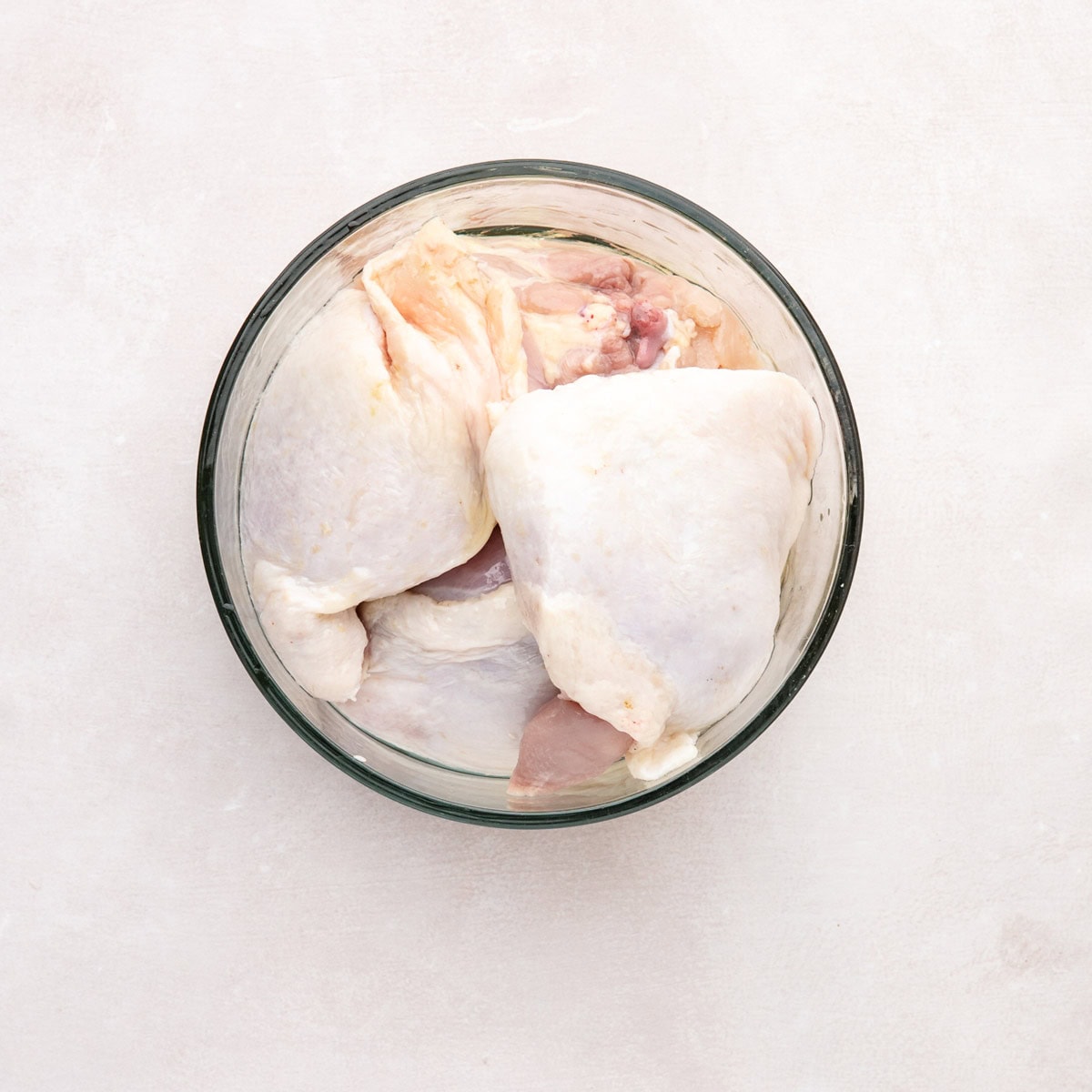 Chicken thighs in a bowl.
