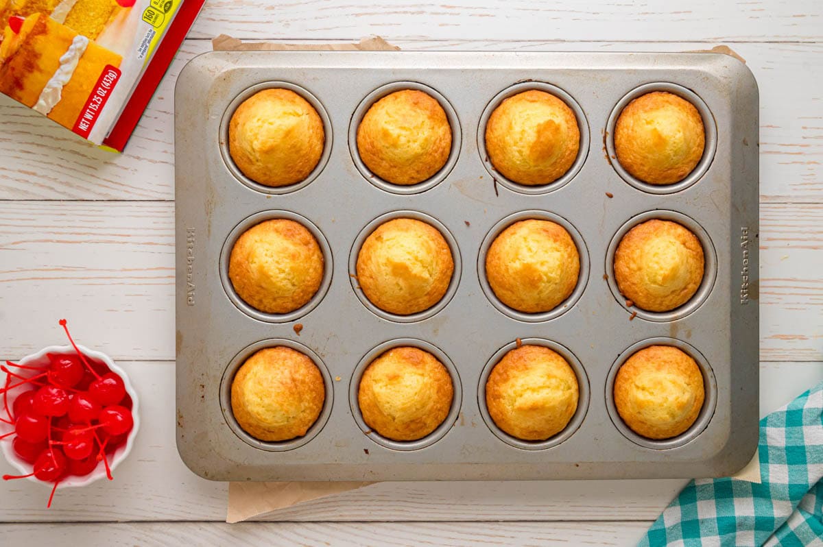 Pineapple upside down cupcakes in the pan after being baked.