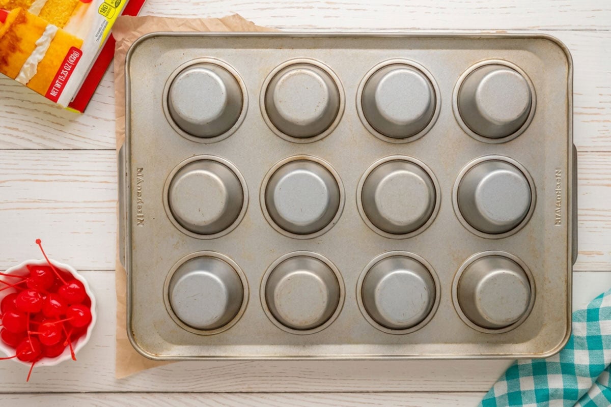 Cupcake tin flipped over to remove the pineapple upside down cupcakes.