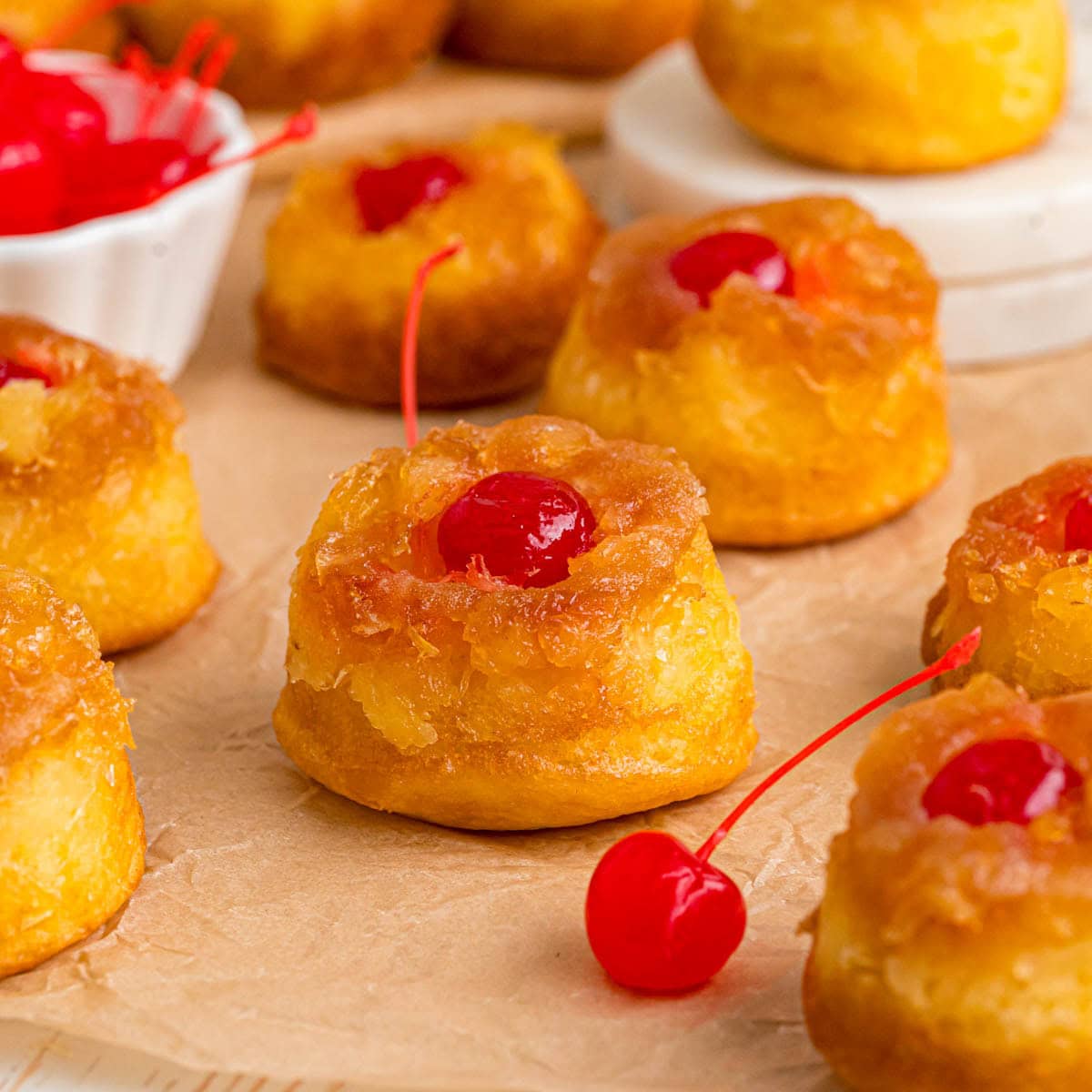 Pineapple upside down cupcakes on parchment paper.