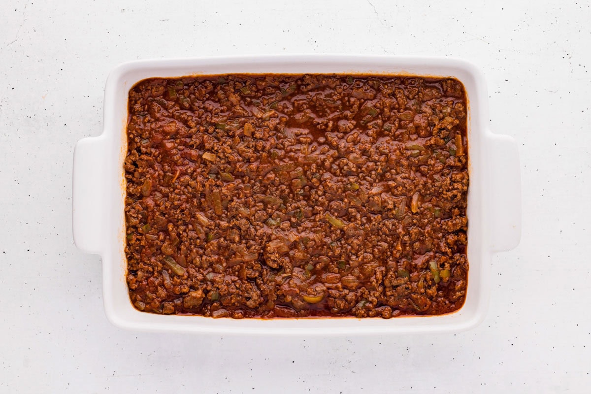 Sloppy joe beef mixture placed in the bottom of a casserole dish.