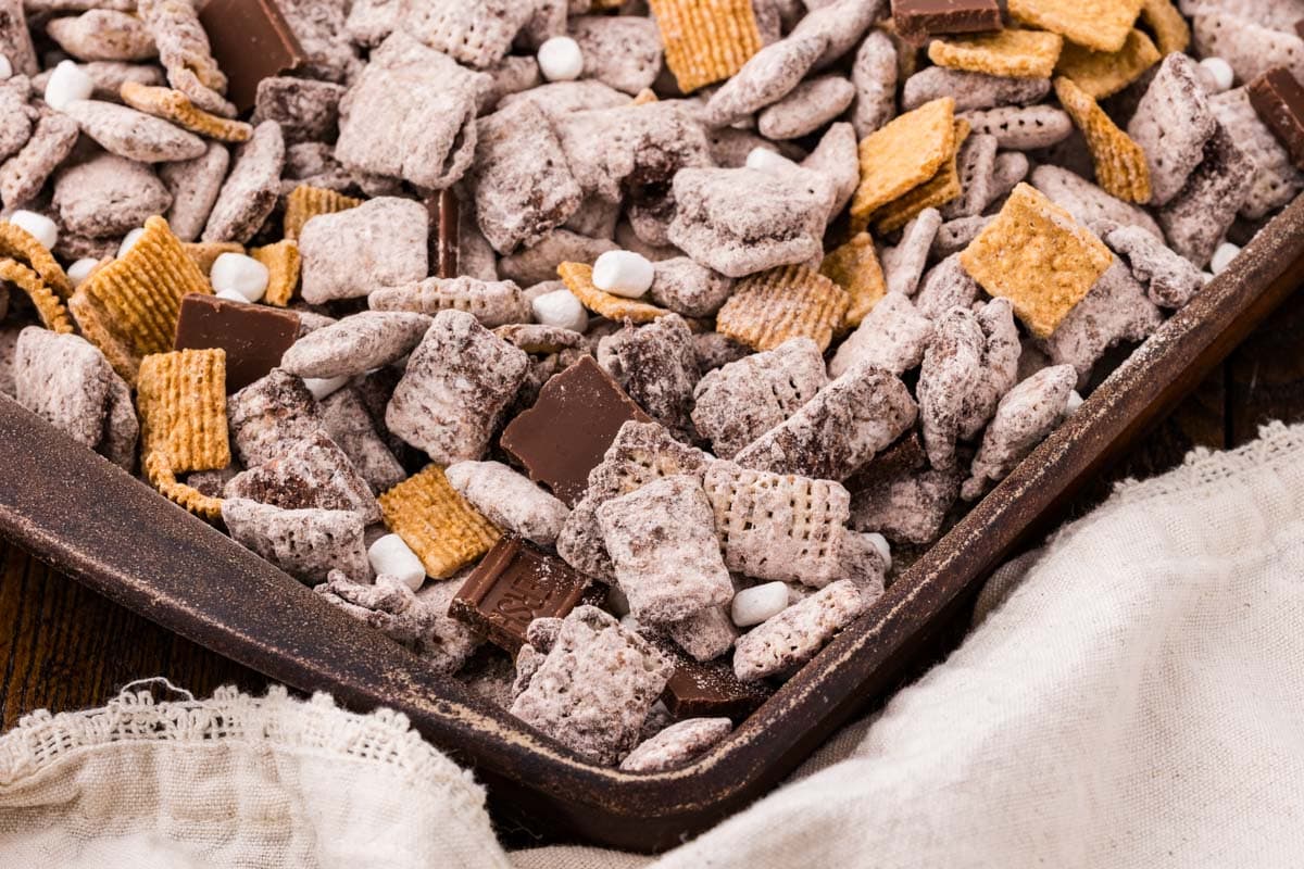 Corner of a sheet pan of s'mores muddy buddies.