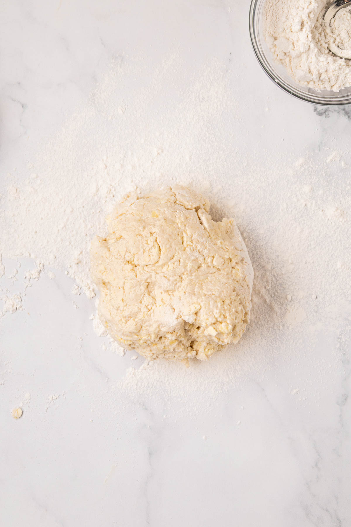 Dough in a ball on floured countertop.