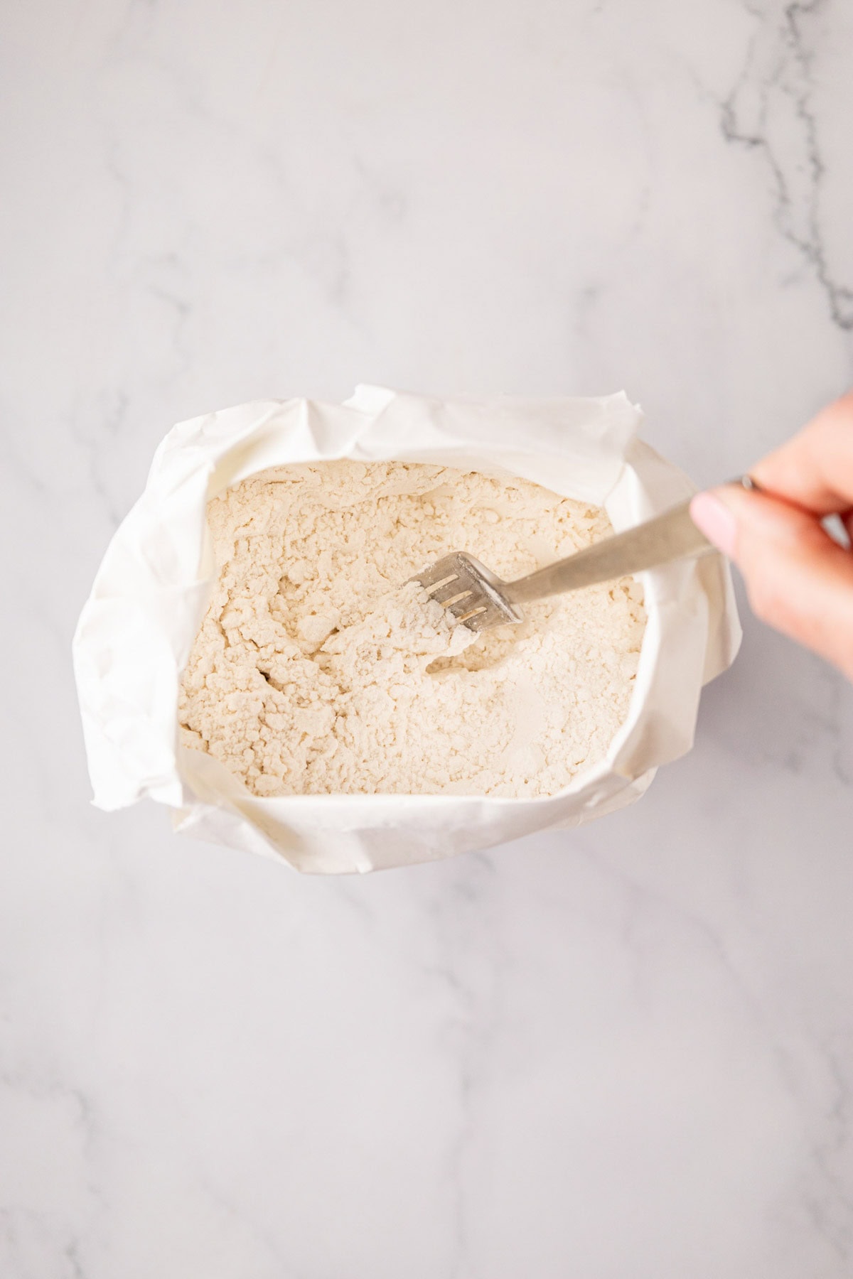 Fluffing flour with a fork.