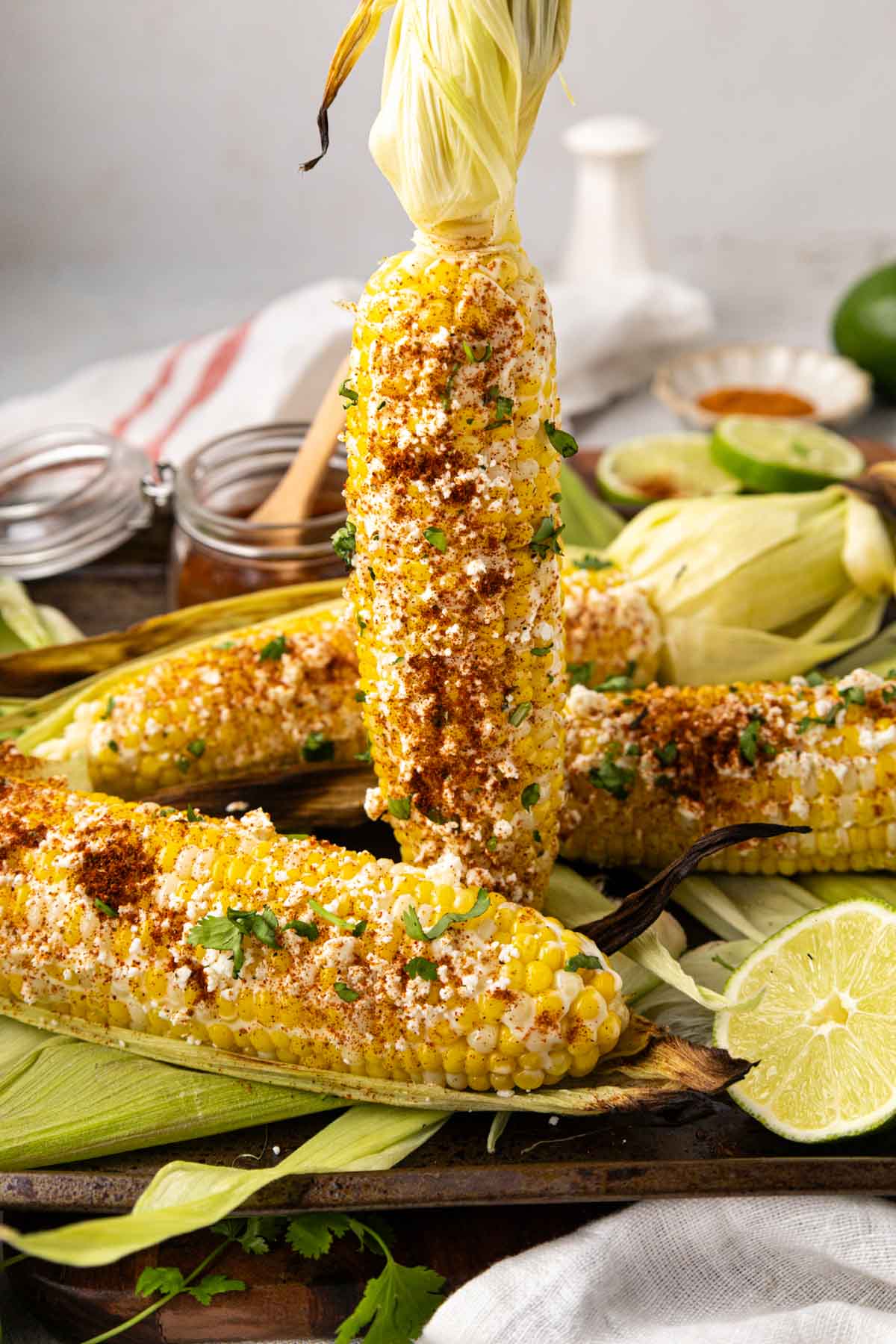 Holding a piece of Mexican street corn upright.