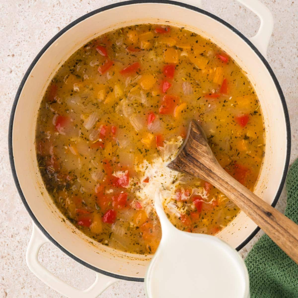 Pouring cream into the Italian sausage soup.