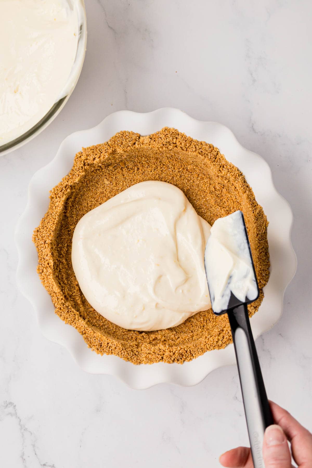 Filling being poured into the pie crust.