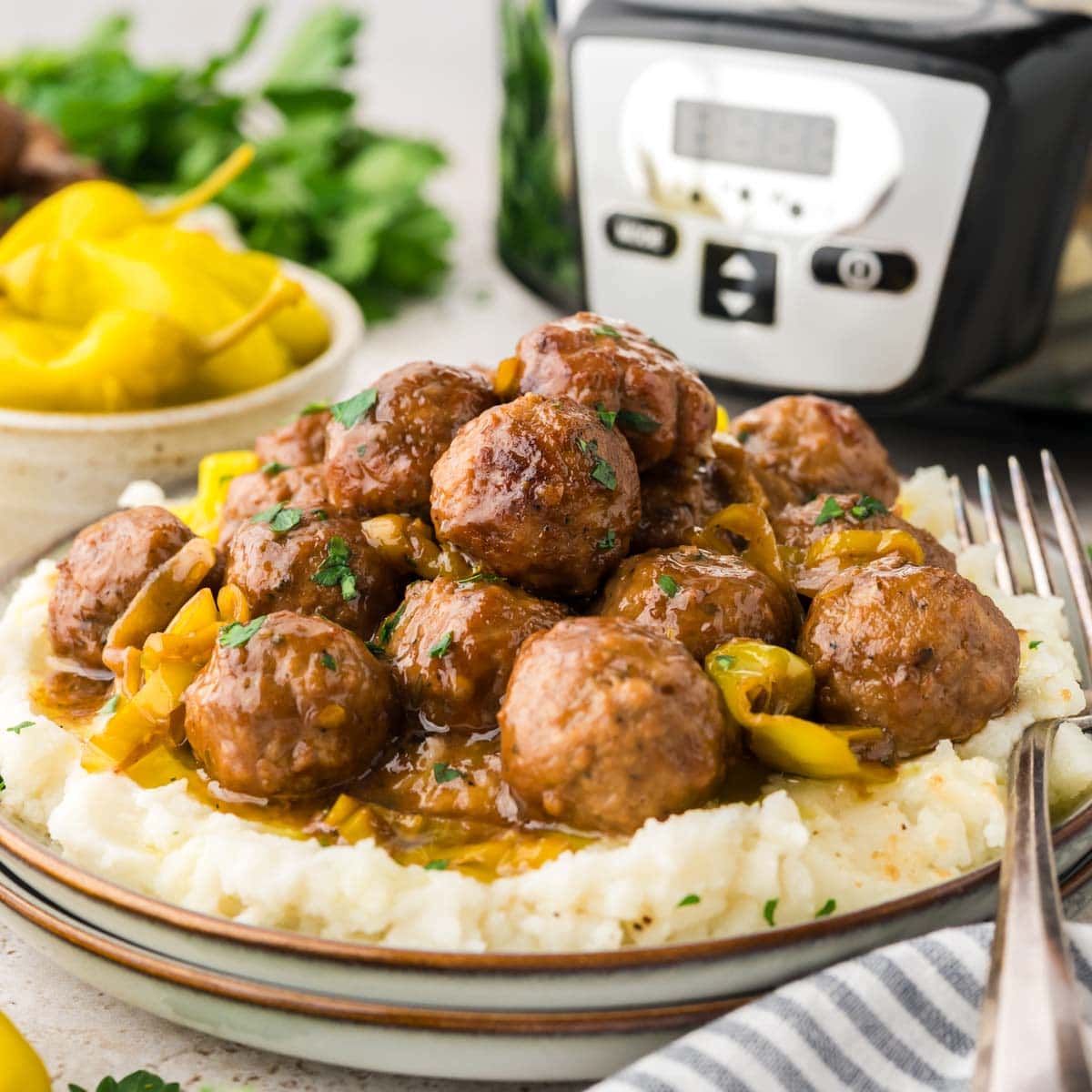 Side view of Mississippi meatballs served on a plate with mashed potatoes.