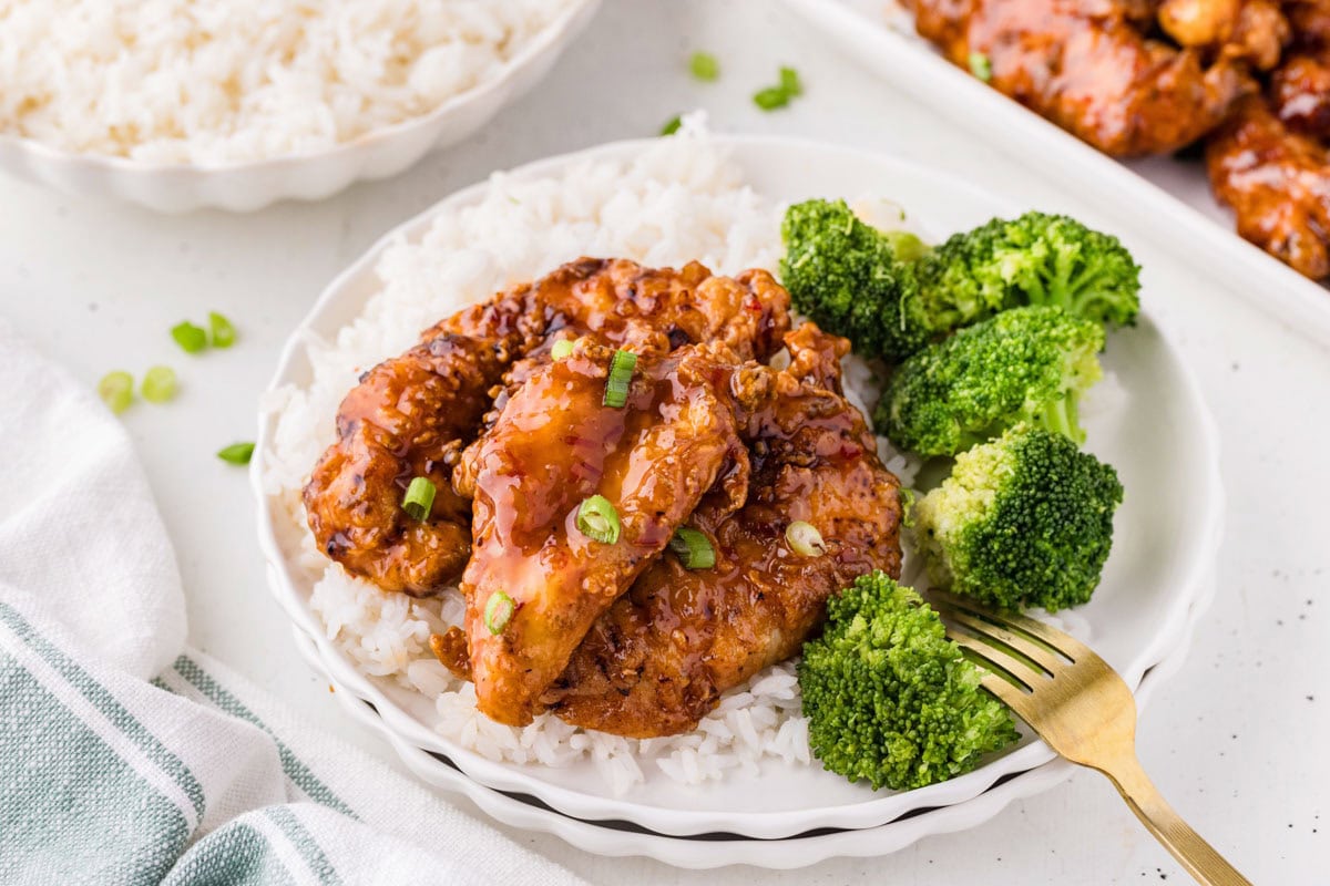 Sweet chili chicken tenders on a bed of rice served with broccoli.