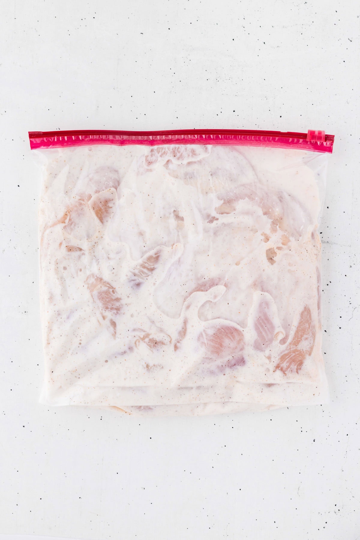 Ziplock bag of chicken tenders in a buttermilk marinade.