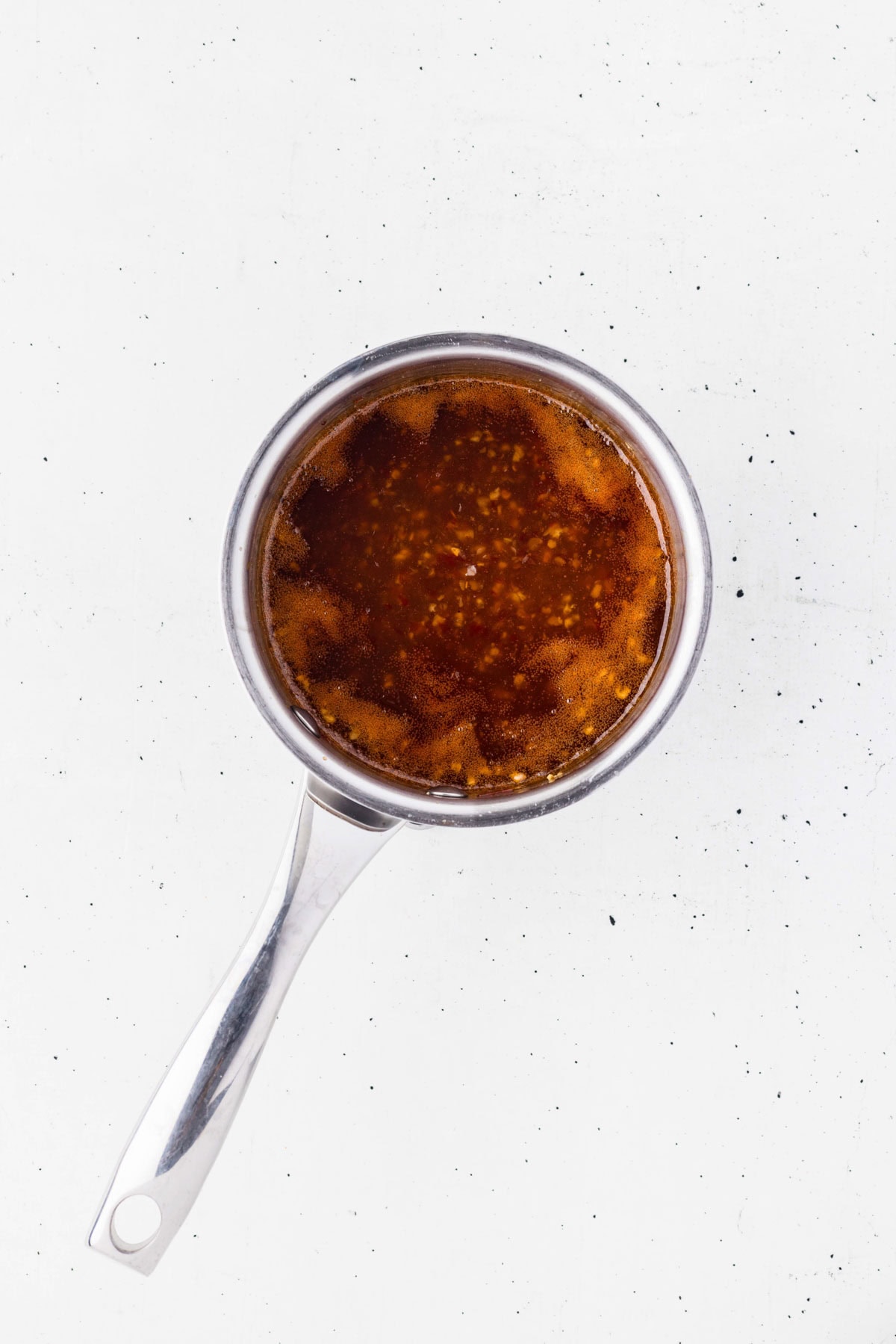 Simmering sweet chili sauce in a saucepan.