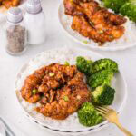 Sweet chili chicken fingers served on a plate with rice and broccoli.