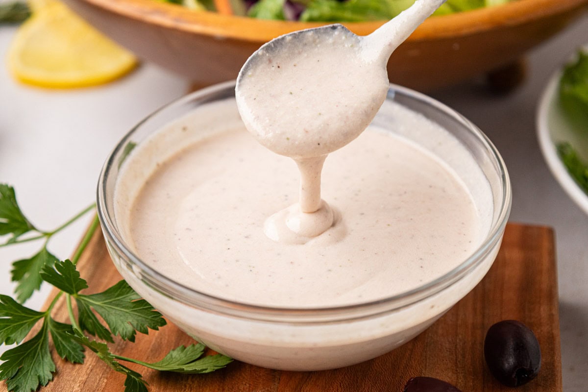 A spoon stirring a bowl of Carrabba's copycat house dressing.