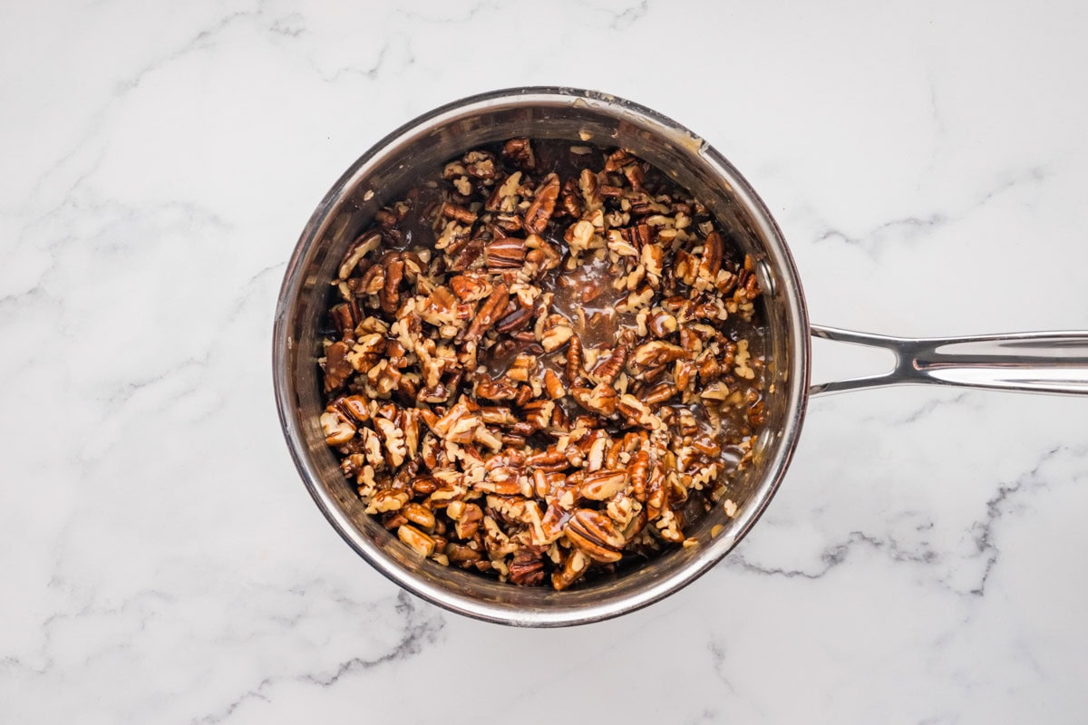 Cooked pecan topping mixture in a saucepan.
