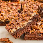 Side view of a pecan pie brownie leaning on another one.