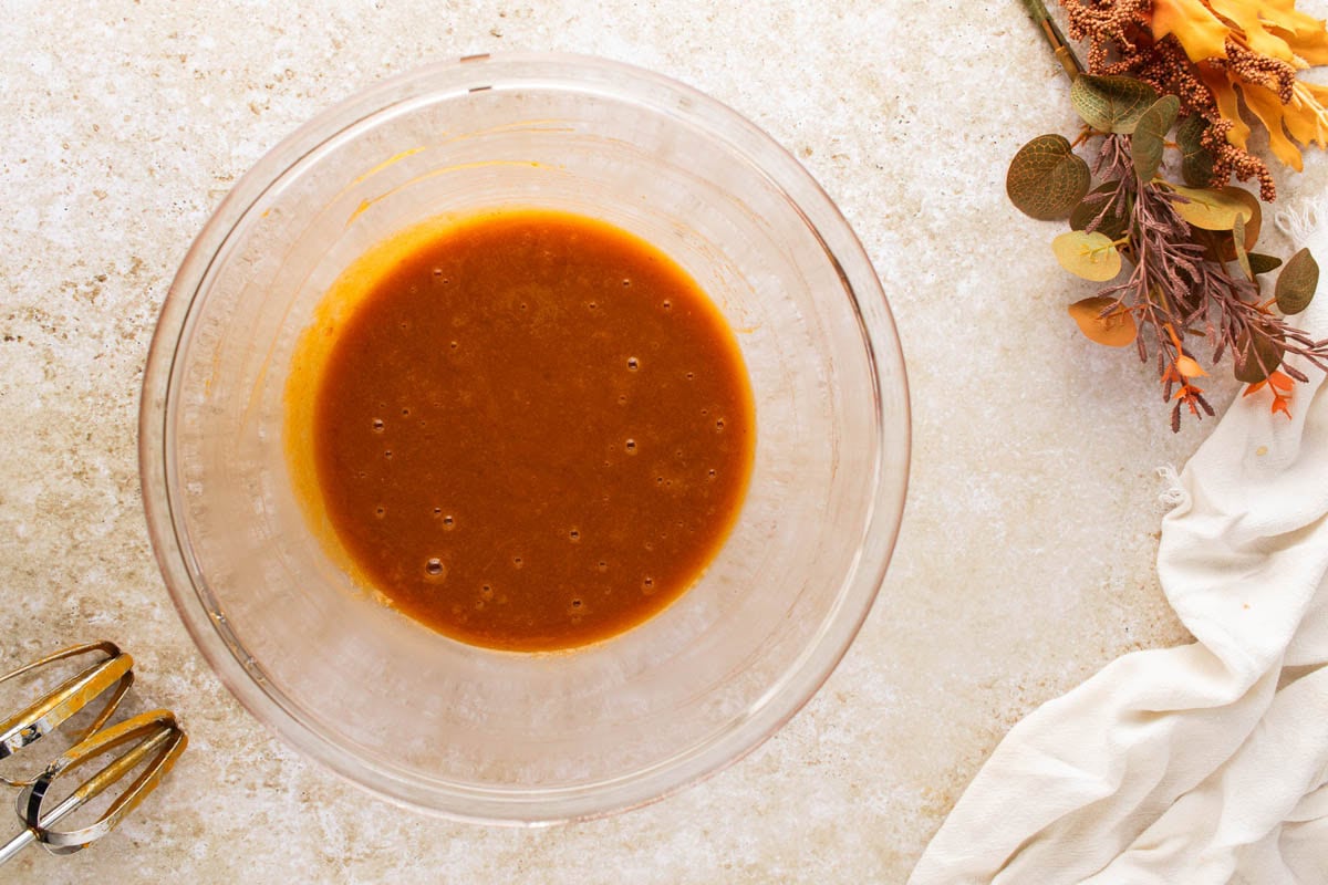 Pumpkin, oil, egg, sugar, and vanilla mixed together in a mixing bowl.