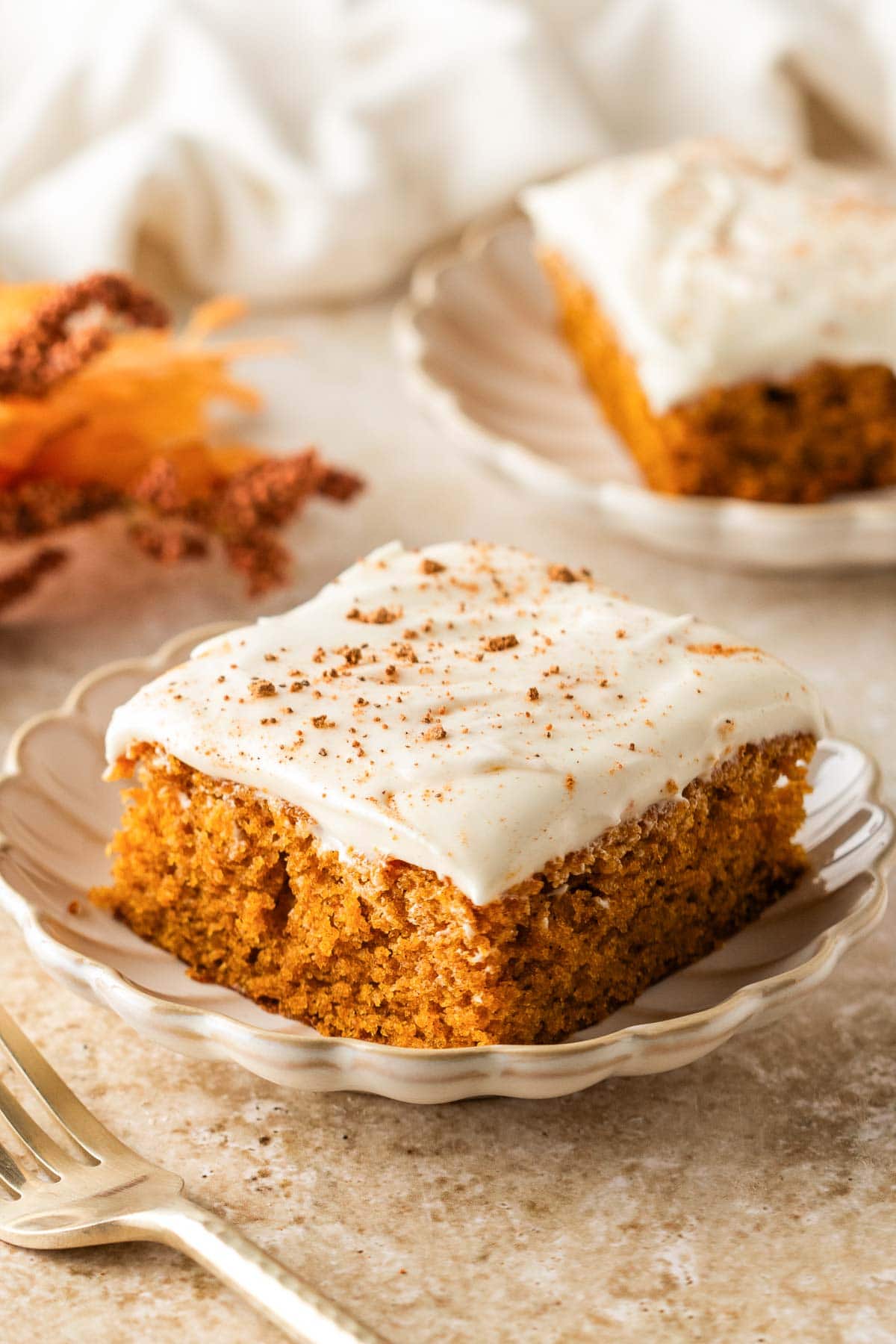 Pumpkin bar with cream cheese frosting on a plate.