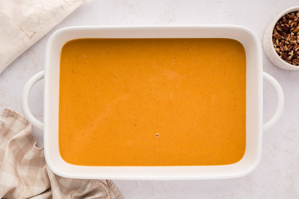 The pumpkin custard poured into the bottom of a baking dish.