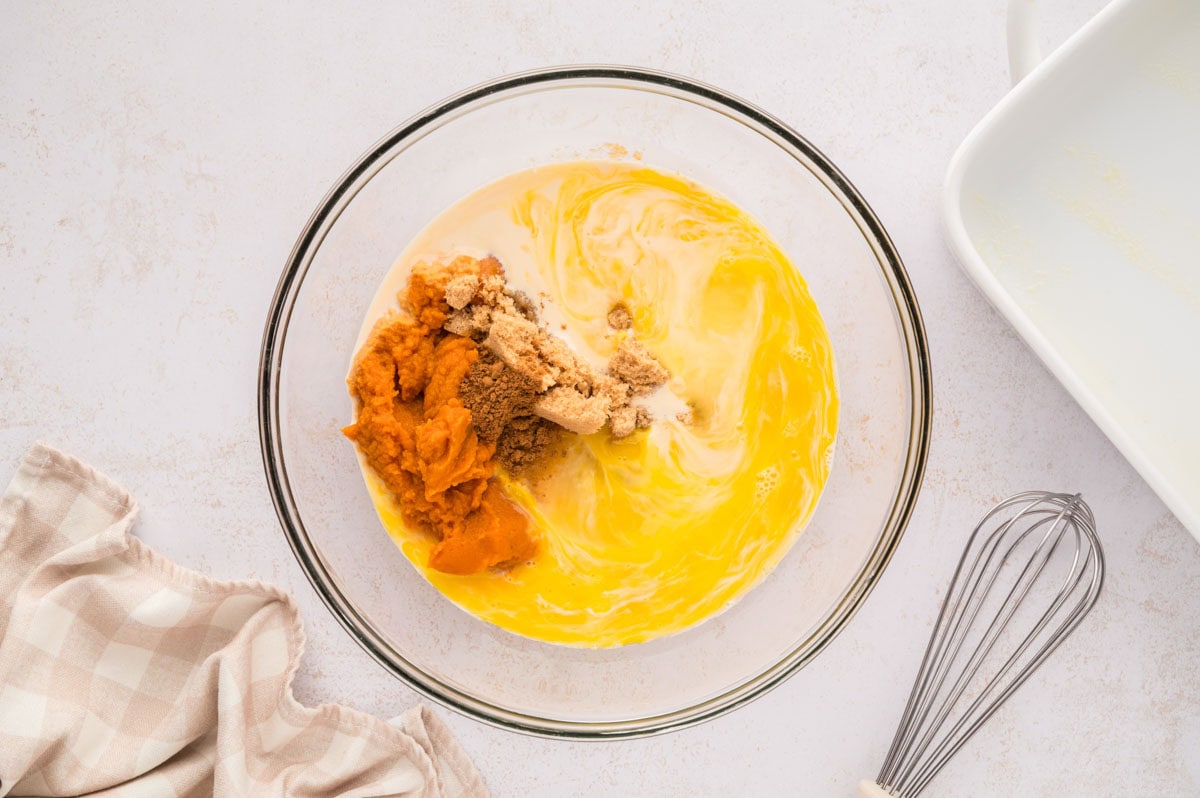 Pumpkin custard ingredients in a clear bowl.