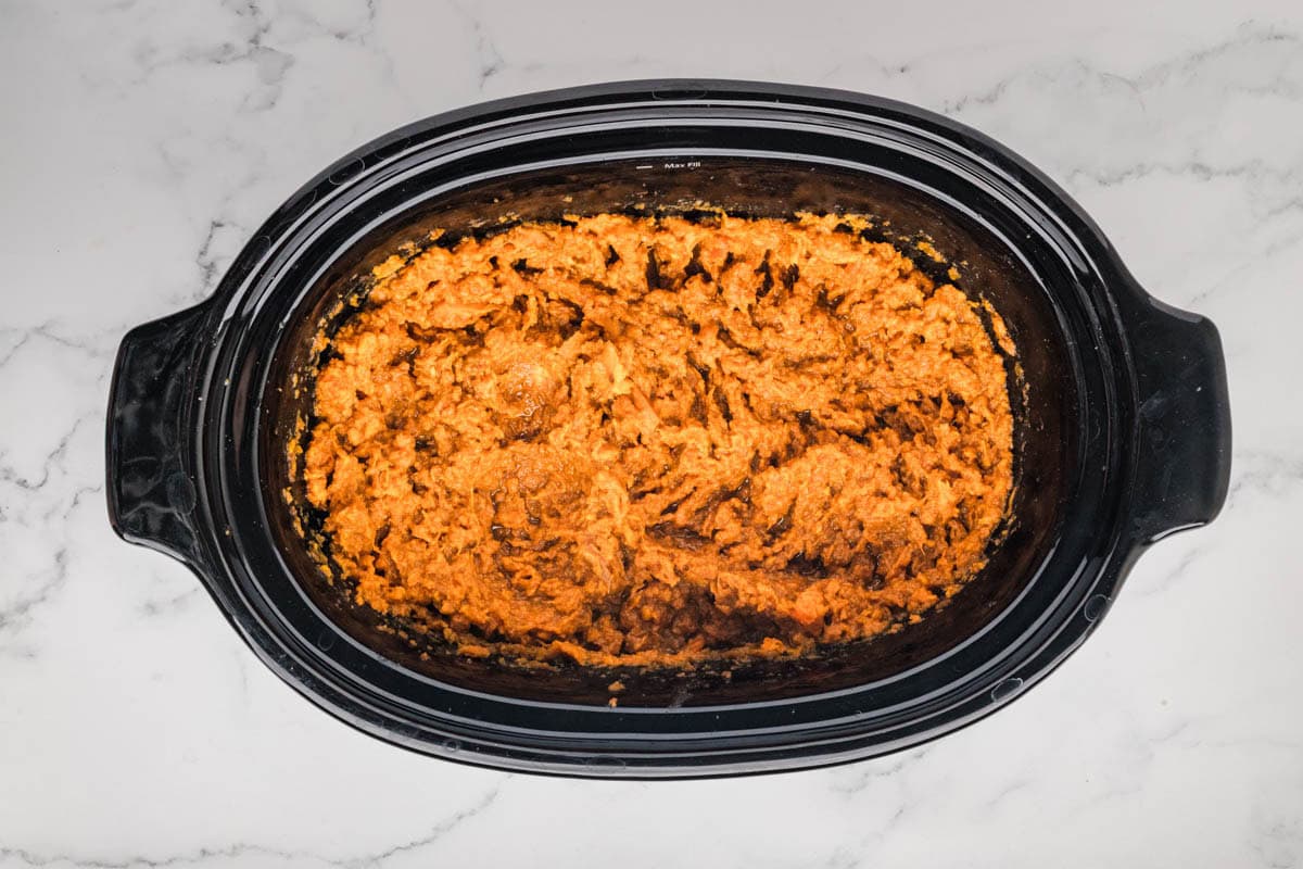 Mashed sweet potato mixture in the bottom of a slow cooker.