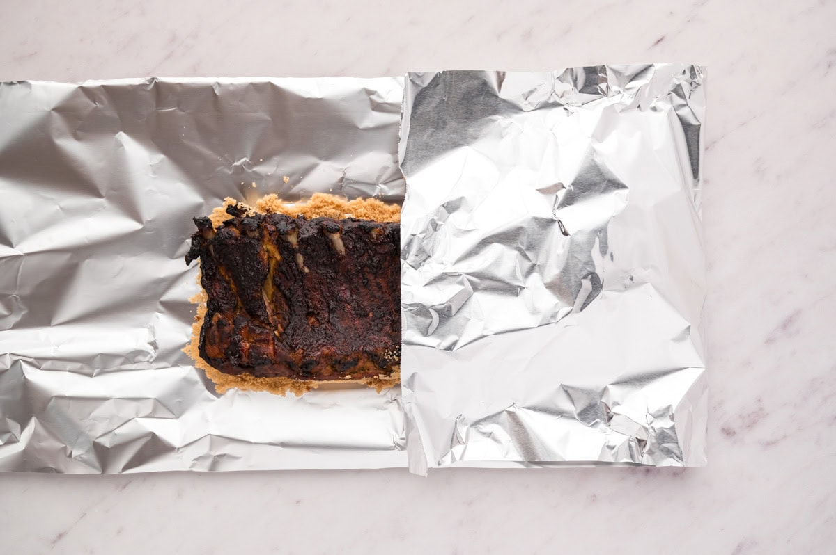 Folding foil over the ribs to wrap it.