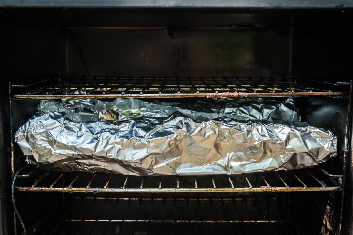 Ribs wrapped in foil in the smoker.
