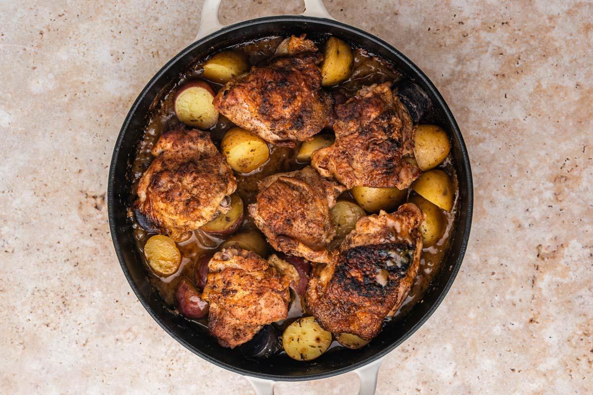 Braised chicken thighs in the skillet after cooking.