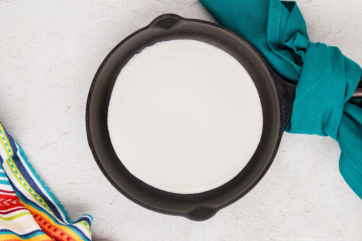 Heavy cream simmering in a saucepan.